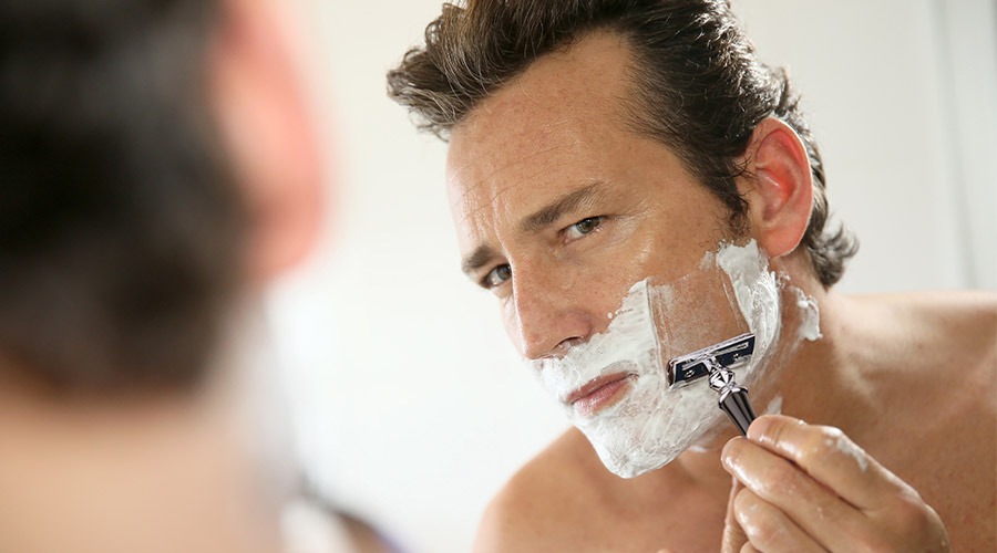 man shaving face with vali safety razor